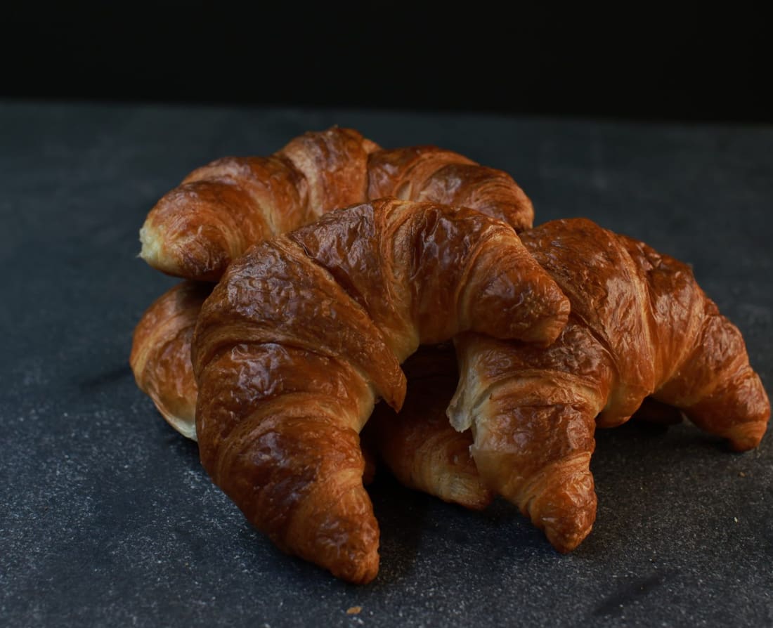 Drei Croissants auf dunklem Schiefer